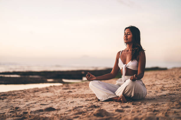 istock Woman practicing meditation on the beach during a peaceful sunset 2192162859