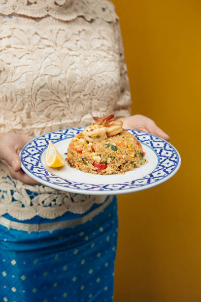 istock Authentic Thai fried rice with prawns, traditional Khao Pad Goong, flavorful stir-fried rice with shrimp, served with fresh lemon, elegant plating in a blue and white ceramic dish, cultural Thai cuisine experience 2192164174