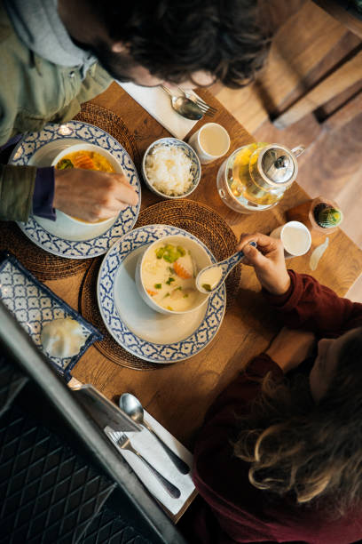 istock Authentic Thai dining experience, traditional Tom Kha Gai coconut soup with jasmine rice, warm and cozy restaurant setting, cultural Southeast Asian cuisine, gourmet Thai food served in decorative ceramic bowls 2192164218