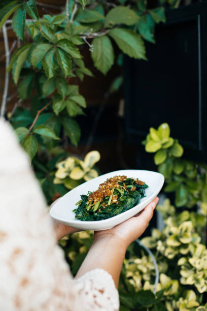 istock Stir-fried spinach with oyster sauce, Thai restaurant, traditional Thai dish, served on a white plate, garnished with fried garlic and chili, fresh green leaves in the background, authentic Thai cuisine, healthy vegetable dish 2192164286