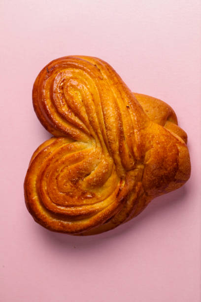 Unique heart-shaped pastry arranged on a pink background