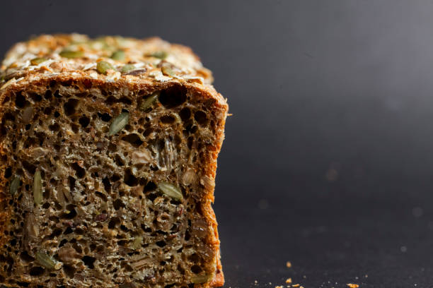 istock Freshly baked loaf of rustic seed bread displayed on dark surface 2192170931