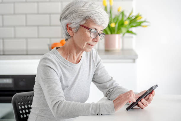 istock Grey-Haired Attractive Woman Searches For Information On Phone 2192173056