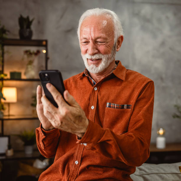 istock senior man have fun while use mobile phone at home 2192174323