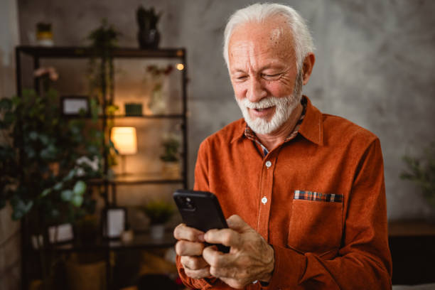istock senior man have fun while use mobile phone at home 2192174500