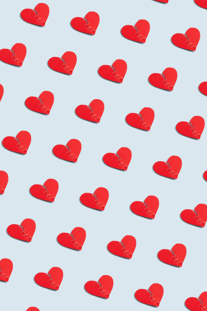istock Red paper craft torn heart pattern on pastel blue background, vertical wallpaper. Creative Valentine's Day poster idea with broken heart 2192175859