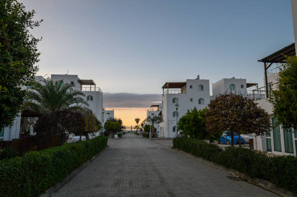 istock Serene coastal pathway lined with white buildings and greenery at sunset, inviting relaxation and exploration 2192178778