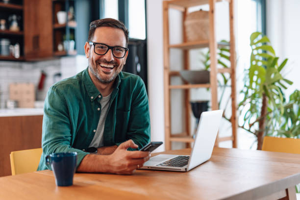 istock Happy businessman working from home using laptop and smartphone 2192181434