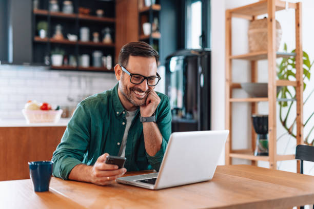 istock Happy businessman working from home using laptop and smartphone 2192181446
