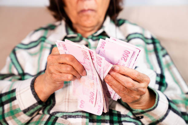 istock Hands holding and counting Turkish money 2192183251