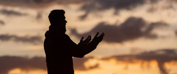 Silhouette of prayer having worship and praying with hands open at sunset Silhouette of muslim woman prayer having worship and praying with hands open doing dua to Allah at sunset . High quality photo i love allah in arabic silhouettes stock pictures, royalty-free photos & images
