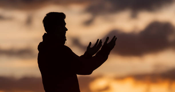 Silhouette of prayer having worship and praying with hands open at sunset Silhouette of muslim woman prayer having worship and praying with hands open doing dua to Allah at sunset . High quality photo i love allah in arabic silhouettes stock pictures, royalty-free photos & images