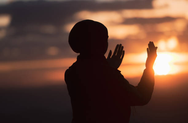 Silhouette of Muslim woman prayer having worship and praying with hands open doing dua to Allah at sunset. Silhouette of muslim woman prayer having worship and praying with hands open doing dua to Allah at sunset . High quality photo i love allah in arabic silhouettes stock pictures, royalty-free photos & images