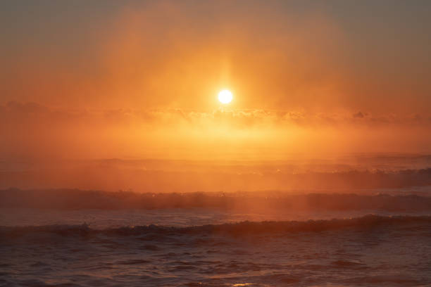 Vibrant Ocean Sunrise with Golden Sky and Rolling Waves