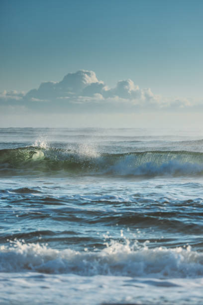istock Ocean Waves Crashing Under a Blue Sky with Puffy Clouds 2192186696