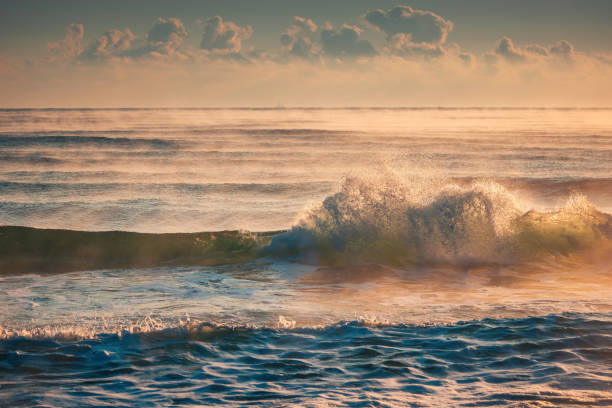 istock Golden Sunrise Over Gentle Ocean Waves with Misty Atmosphere 2192186723