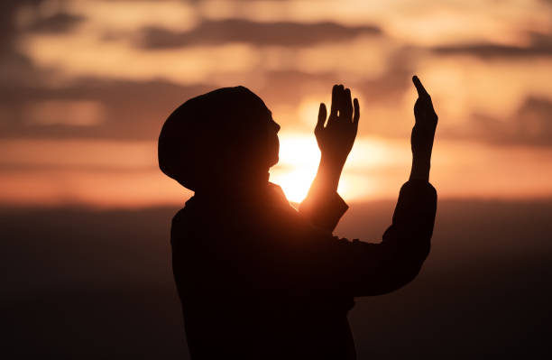 Muslim woman prayer having worship and praying with hands open doing dua to Allah at sunset Silhouette of muslim woman prayer having worship and praying with hands open doing dua to Allah at sunset . High quality photo i love allah in arabic silhouettes stock pictures, royalty-free photos & images