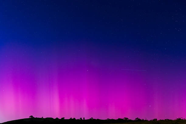 The Southern Lights - Aurora Australis and the predawn night sky filled with pink streaks in Blayney, Central West, NSW, Australia.