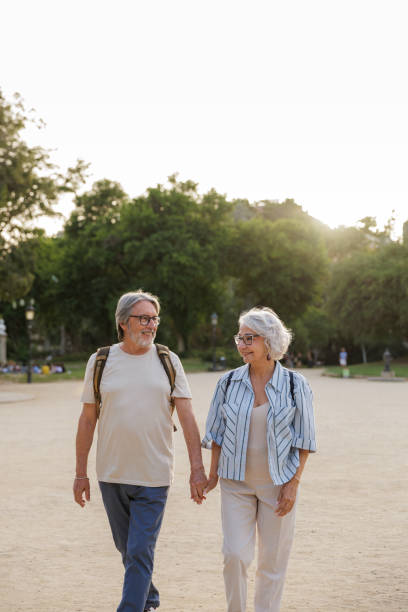 istock Happy senior couple holding hands while walking in park during vacation 2192187874