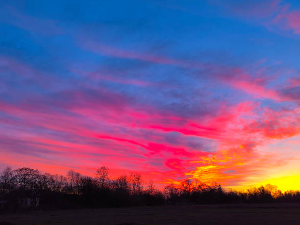 The scattering of sunlight by clouds is well shown. The red part of the spectrum predominates.