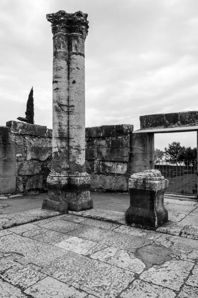 A black and white photo of a stone pillar and a stone pillar with a gate in front of it
