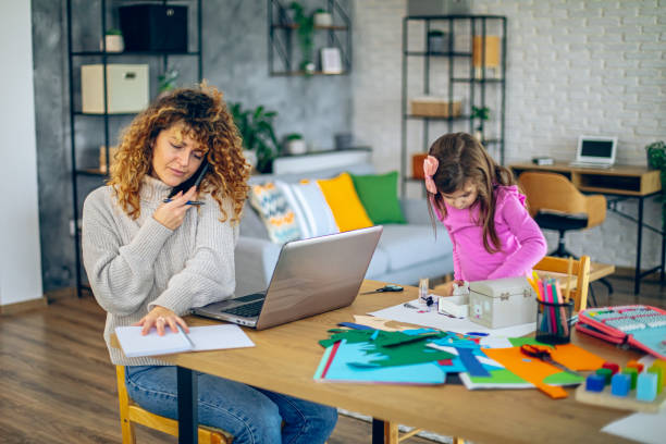 istock Young mother works from home while her daughter plays at the dining table 2192190611