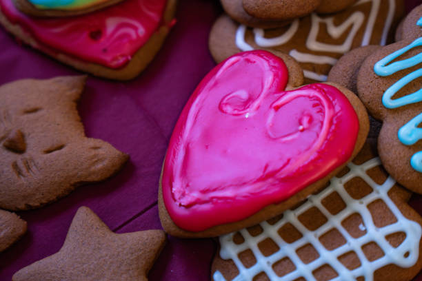 A variety of gingerbread cookies, including heart shapes and cute designs, are beautifully decorated with colorful icing. These festive treats are perfect for celebrating the holiday season at home.