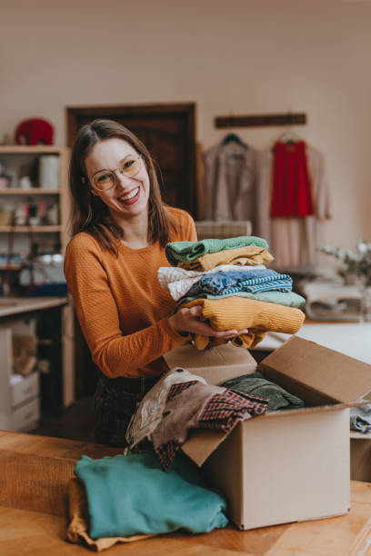 istock Female volunteer sorting old clothes for charity or upcycle 2192191428