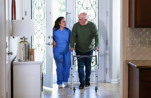 istock Hispanic home caregiver with senior man using walker 2192198420