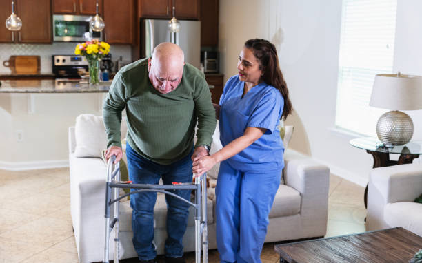 istock Hispanic home caregiver helps senior man use walker 2192198464