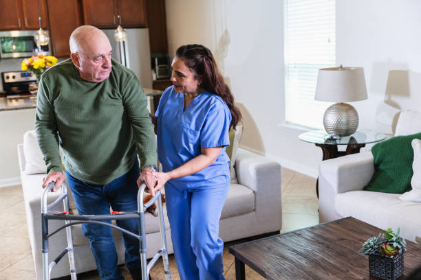istock Hispanic home caregiver helps senior man use walker 2192198473