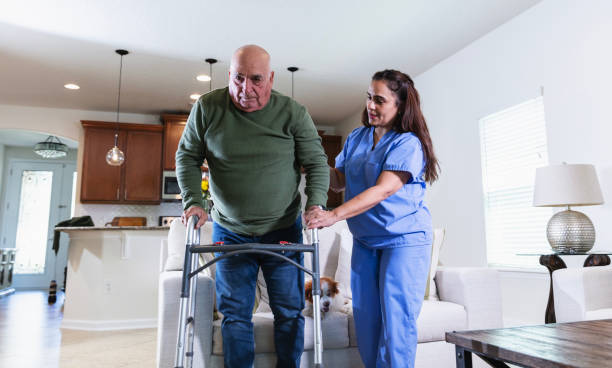 istock Hispanic home caregiver helps senior man use walker 2192198474