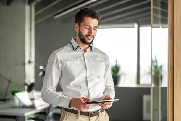 istock Focused Caucasian Businessman with Tablet in Modern Office 2192198597