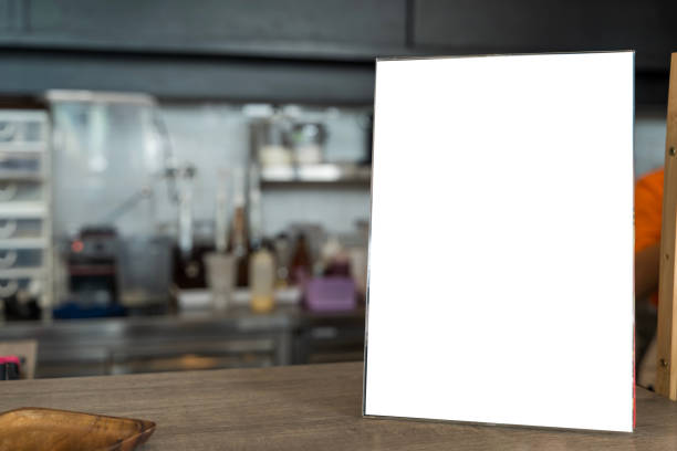 istock Mockup of a menu frame in a bar restaurant, positioned on a wooden table with white sheets of paper and an acrylic tent card 2192200182