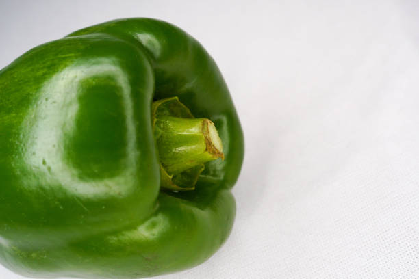 fresh green bell pepper (capsicum) on a white background