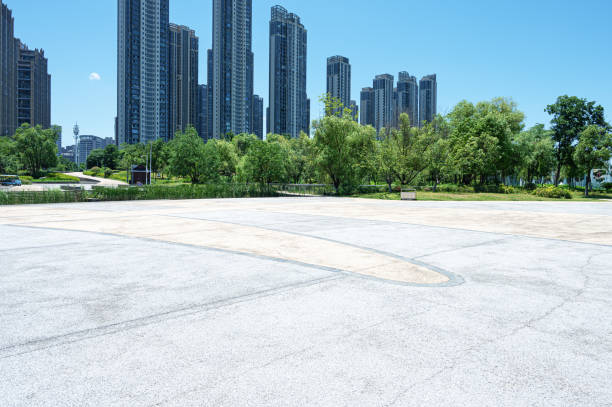 Empty square floor with modern urban skyline and sunny blue sky background