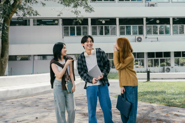 istock Three cheerful young adult university students enjoying a break on campus, laughing and chatting as they walk between classes, embodying the joy of friendship and carefree youth 2192204444