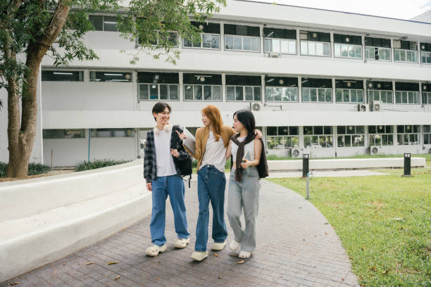 istock Three cheerful young adult university students are walking together on campus, talking and carrying books and backpacks, enjoying their time at school 2192204953