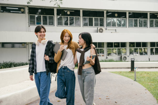istock Three cheerful young adult university students walking and chatting together outside on campus after class, enjoying friendship and the vibrant atmosphere of college life 2192205582