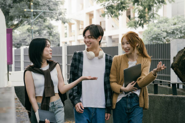 istock Three cheerful young adult university students are walking and talking together on campus, enjoying their time together and discussing their studies 2192206958