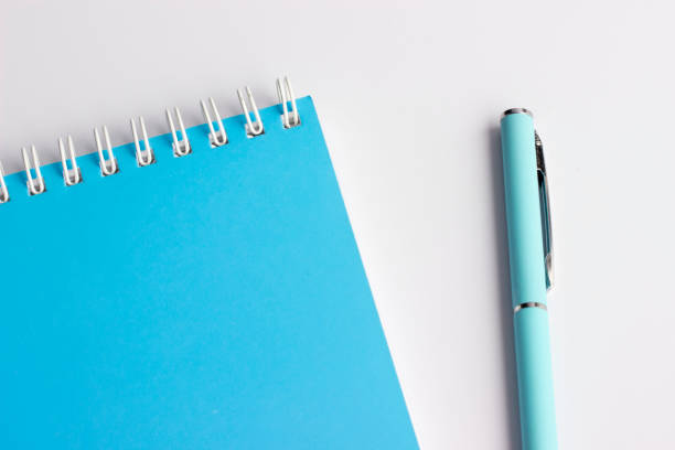 blue notebook and ballpoint pen on a white background