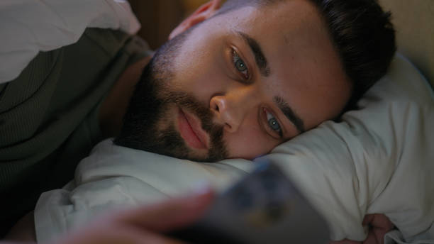 istock Caucasian man lying in bed bedroom user mobile phone smartphone cellphone gadget technology male guy connected scrolling website browsing network cyber ecommerce chatting internet distance communicate 2192216433