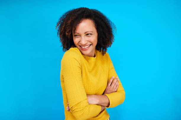 istock Joyful Woman in Yellow on Blue Backdrop 2192217405