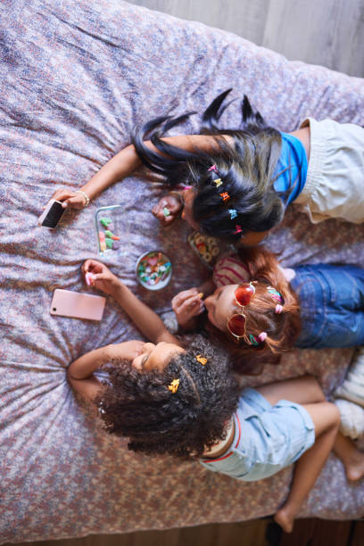 istock Girls' Sleepover Sharing Candy on Bed 2192218117