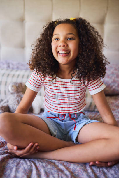 istock Joyful Girl with Curls on Bed 2192218180