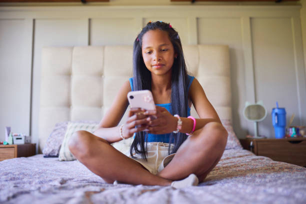 istock Girl Relaxing on Bed with Mobile Phone 2192218239