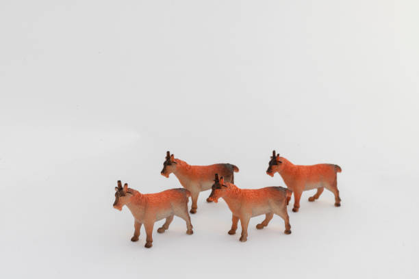 istock Four Miniature Toy Goats in Bright Orange on White Background 2192218727