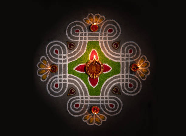 Hand of young indian girl making rangoli from colored powder on diwali eve. These beautiful designs are made in every hindu home to decorate and celebrate the coming of the festivals of diwali, dussera, teej and others