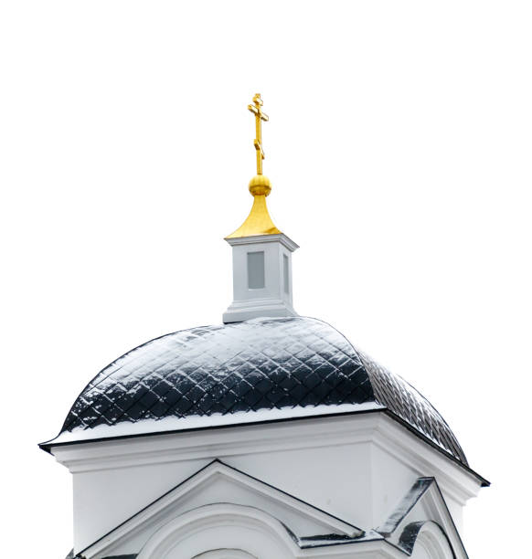A gold cross sits atop a white building. The building is covered in snow, giving it a serene and peaceful appearance