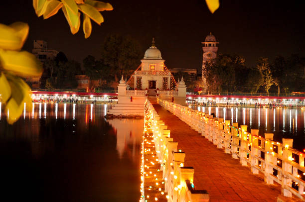 Rani Pokhari (Pond), Kathmandu, Nepal, captured during the Chhath Festival. The temple and bridge glow with vibrant lights, reflecting beautifully on the serene waters at night.